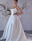 ivory strapless wedding gown with Basque waistline oversize bow detail in the back.