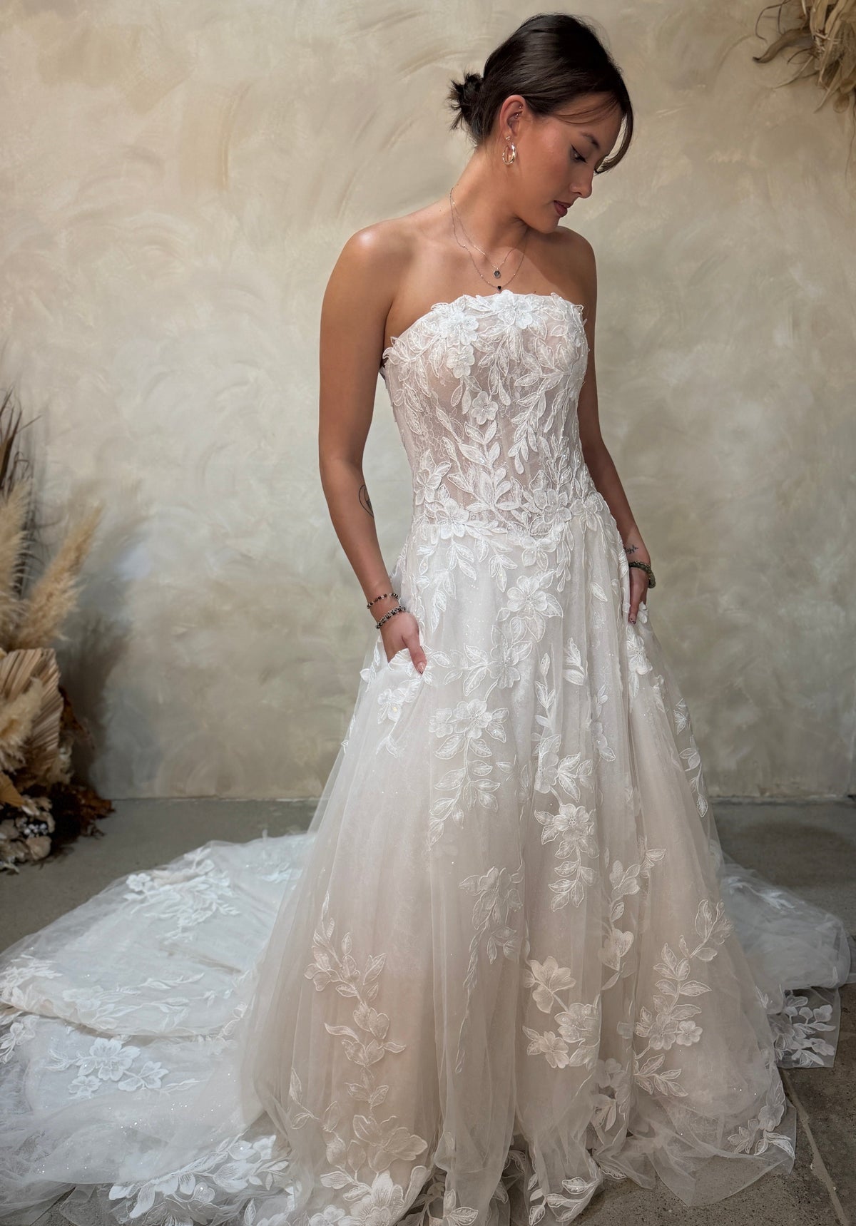 strapless white lace beaded and tulle wedding gown with a full skirt and train.