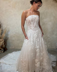 strapless white lace beaded and tulle wedding gown with a full skirt and train.