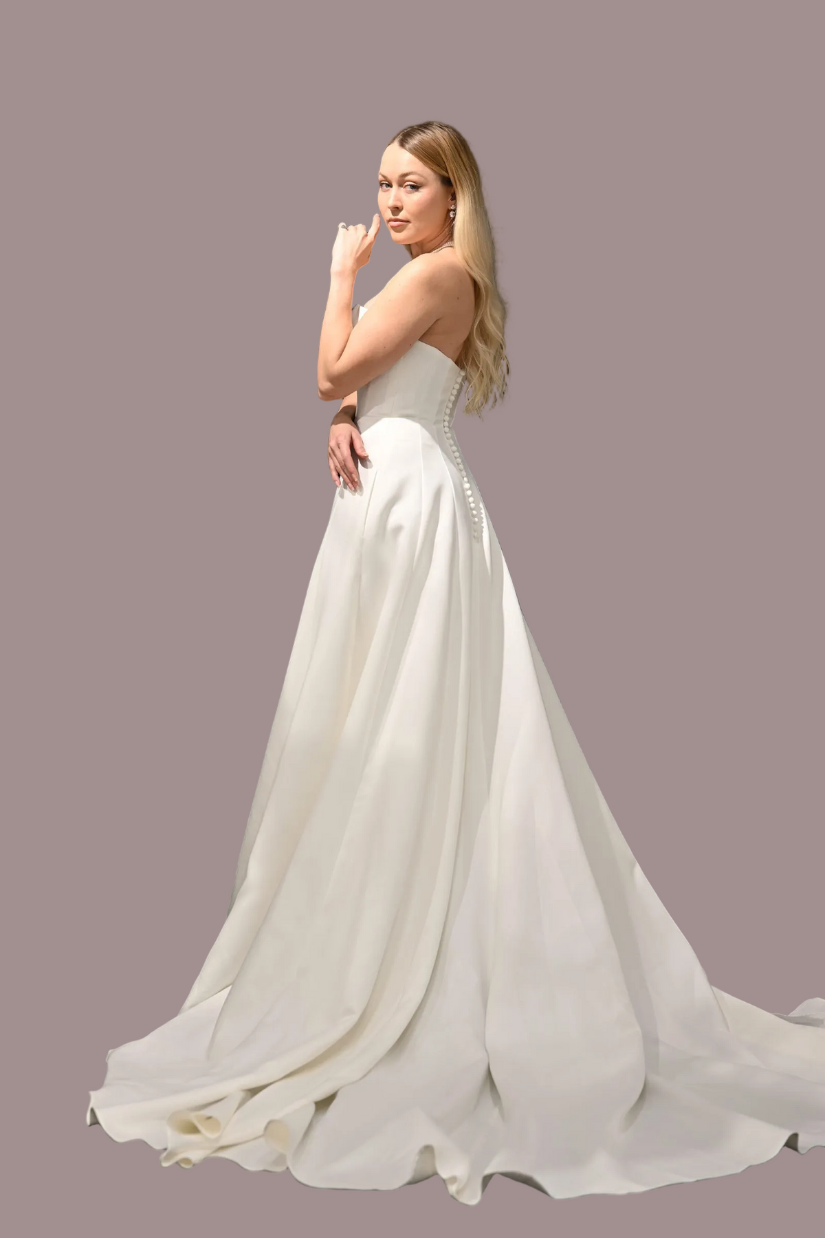 strapless white wedding gown with a fitted bodice, and a full flowing skirt with a long train.